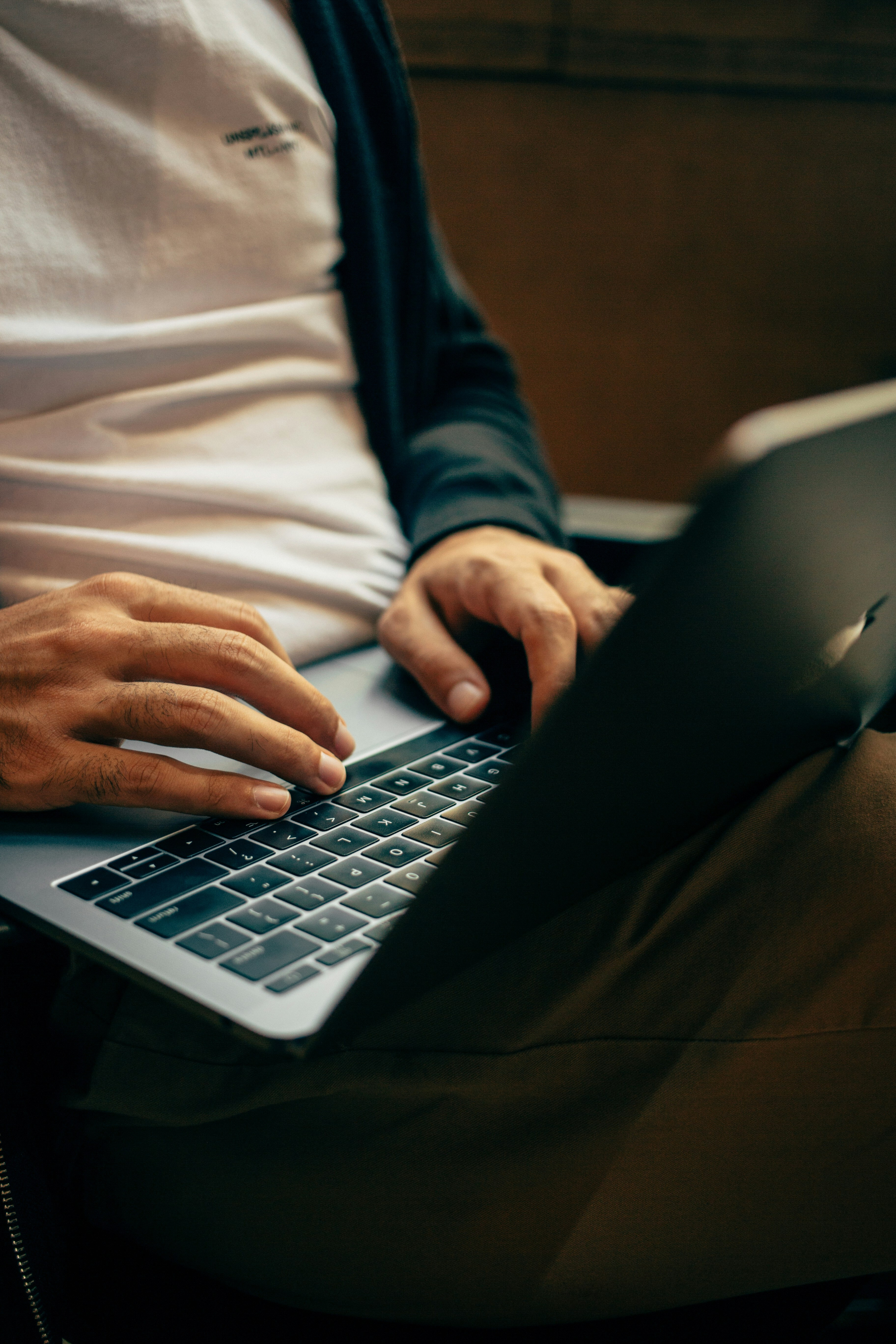 Close-up of a person’s hands typing on a laptop keyboard